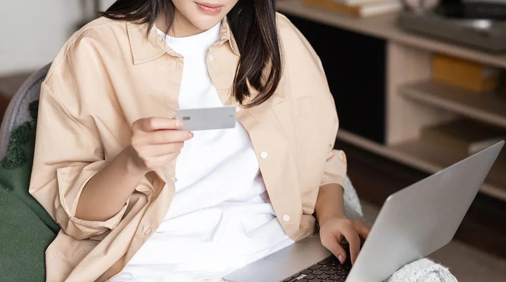 女性がパソコンを触りながらオイルメンバーのカードを眺めている画像