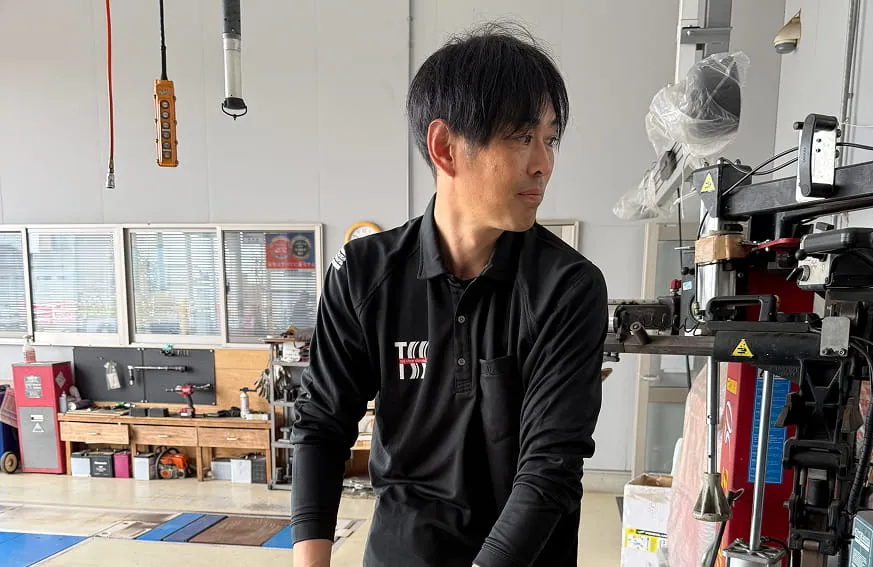 整備工場でタイヤにエアを充填する作業スタッフの様子