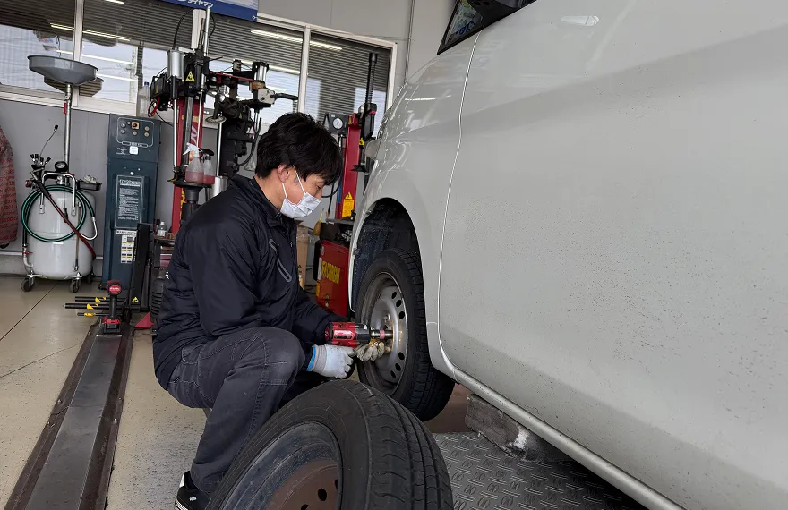 自動車のタイヤ交換作業を行う整備士の様子