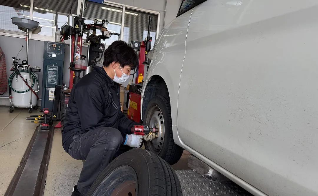 自動車のタイヤ交換作業を行う整備士